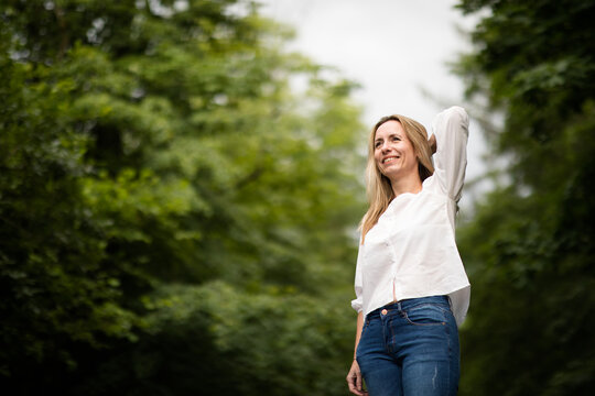 Portrait Of A Relaxed Middle Aged Woman Outdoors, Looking Happy, Enjoying The Life