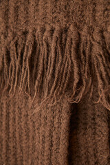 Closeup of brown sustainable cloth, handmade and eco friendly scarf  with knitting fringes