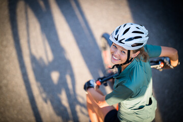 Pretty, young woman with her mountain bike going for a ride past the city limits, getting the daily cardio dose © lightpoet
