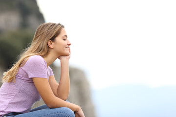 Happy woman relaxing meditating in the mountain