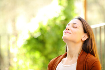 Naklejka premium Relaxed woman breathing fresh air in a garden