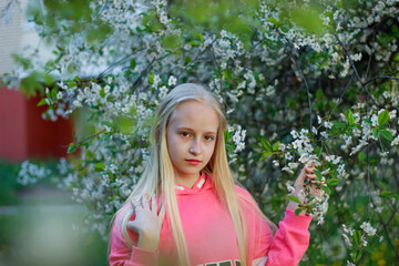 portrait of a teenage girl with blond hair in an early spring park. high quality