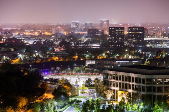 Night time view of the converging downtown skylines of Irvine, Newport Beach, Costa Mesa, and Santa Ana, California, USA.