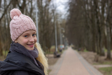 portrait of a teenage girl with blond hair in an early spring park. high quality
