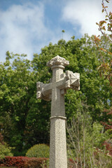 Sandstone cross with trees in the background