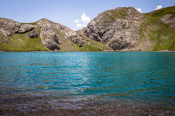 Panoramic view of a beautiful lake with turquoise blue water in summer, at the foot of the lake
