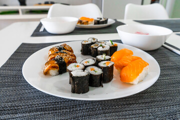 Fresh sushi and rolls in a white plate. Sushi lunch