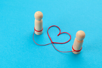Passion and love in a couple of lovers, concept. Two human figures and a thread between them in the shape of a heart.