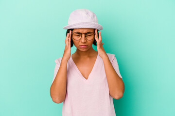 Fototapeta premium Young mixed race woman isolated on blue background touching temples and having headache.