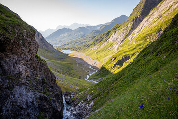 Nice view of a valley surrounded by mountains with a waterfall and a river