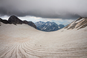 Panoramic view of a glacier with snow-capped mountains in the background