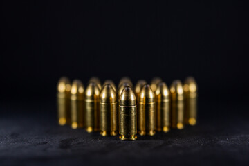 9 mm bullets on a black background. Photo with shallow depth of field.