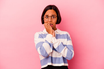 Young mixed race woman isolated on pink background biting fingernails, nervous and very anxious.