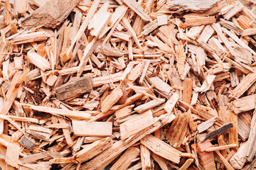 Small pile of wood chips background, top view. Waste from the woodworking industry, fuel and raw materials for heating solid fuel industrial boilers on wood chips