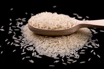 Heap of white rice isolated on black background. rice close-up.