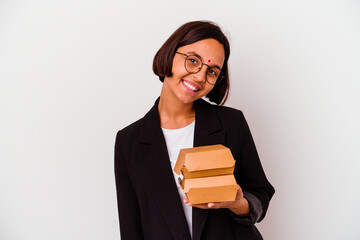 Young business indian woman eating burgers isolated happy, smiling and cheerful.