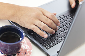 Hands typing in a notebook