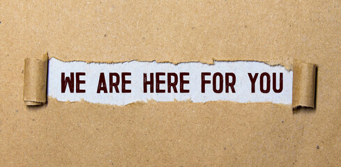 The text 'we are here for you' appearing behind torn paper. Business concept.