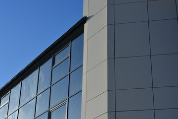 Fototapeta na wymiar fragment of the wall of a modern business center. blue sky background.