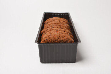Oatmeal cookies with raisins in a plastic container on a white background