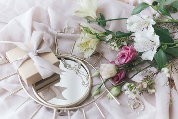 Happy Women's and Mother's day. Stylish gift, jewelry and  bouquet on boho mirror on soft fabric