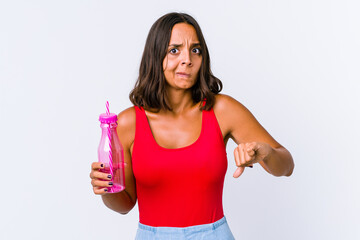 Young mixed race woman holding a milk shake isolated showing thumbs up and thumbs down, difficult choose concept