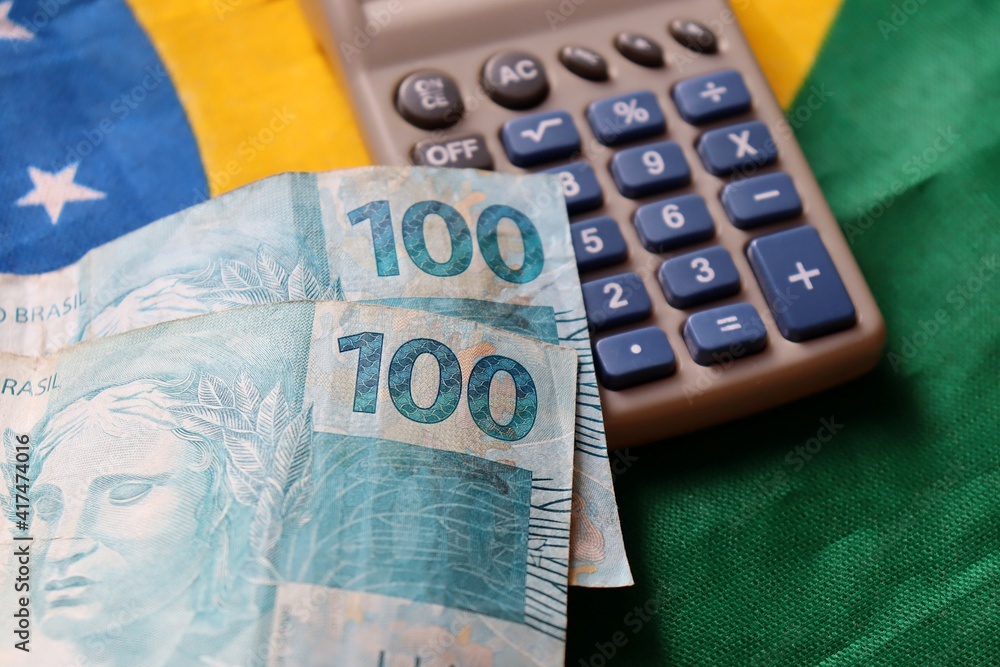 Wall mural brazilian money and calculator on top of brazilian flag. economy concept.