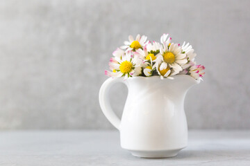 Daisy flowers in a vase on gray background with copy space. minimalist style. Spring holidays concept. Banner. Soft focus