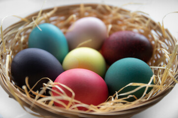 Obraz na płótnie Canvas Easter eggs in a wicker basket with straw