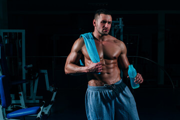 Fototapeta na wymiar Drink water. Shirtless sportsman resting after training at the gym sitting on the floor drinking water with his eyes closed copyspase pleasure resting relax sports water lifestyle hydration vitality.
