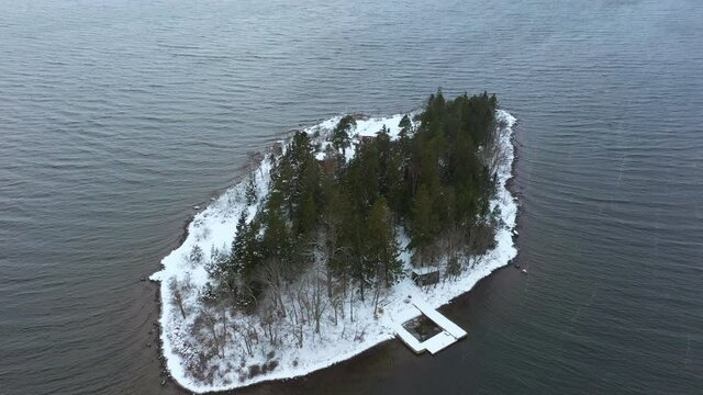 Remote island covered in snow at winter. Flying over the Swedish east coast archipelago.