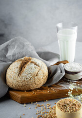 Homemade loaf of freshly baked green buckwheat bread and organic buckwheat milk. Wooden, linen napkin. Harmless,wellness, gluten free healthy baking for vegans. Alternative bread and vegeterian milk