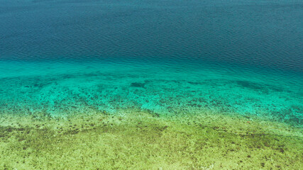 Fototapeta na wymiar Blue background with transparent sea water copy space for text. Sea water surface in lagoon and coral reef. Top view transparent turquoise ocean water surface. background texture