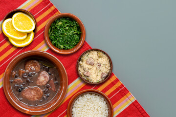 Brazilian feijoada. Typical Brazilian food with black beans and pork. Top view on white table with red towel.