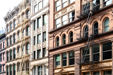 Block of old historic buildings with windows and fire escapes in the SoHo neighborhood  of...