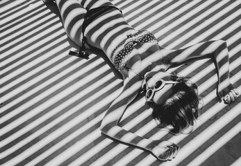 girl lying down on a floor with shadows.