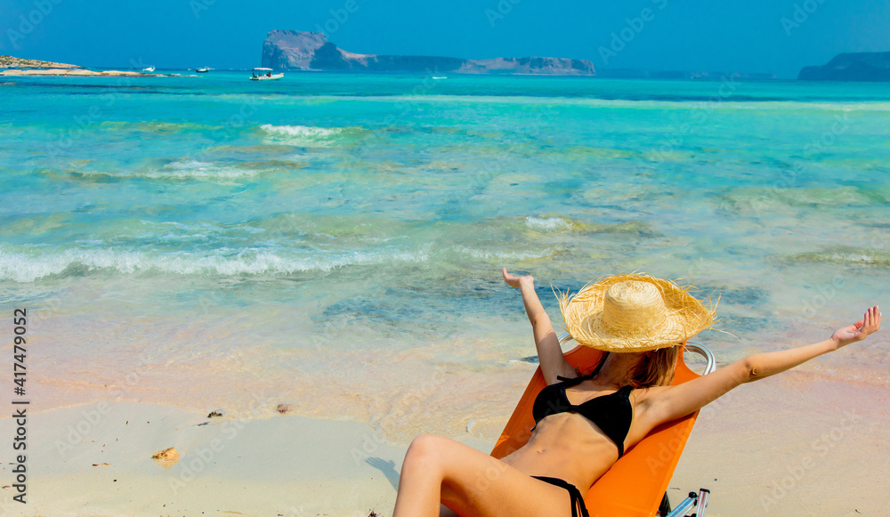 Wall mural girl in black bikini and with hat on Balos beach