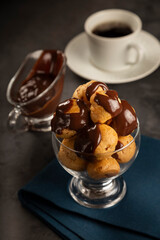 Profiteroles covered with chocolate sauce.