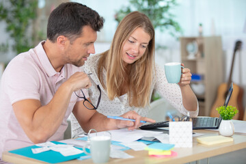 Obraz premium unhappy young couple sitting on sofa near table with bills