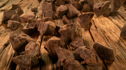 Rolling pieces of chocolate placed on wooden planks