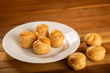 Delicious profiteroles on the table. Profiteroles dessert. Image with selective focus.
