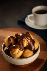 Profiteroles covered with chocolate sauce.