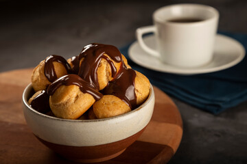 Profiteroles covered with chocolate sauce.