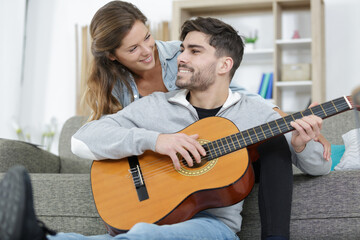 a couple playing acoustic guitar