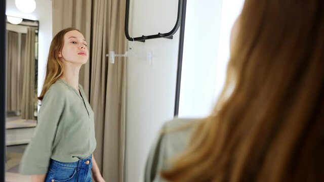 Tween girl standing in fitting room in clothing store.