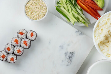 Sushi rolls prepared by professional asian chef with traditional Japanese ingredients. Salmon, rice, vegetables, sesame seeds. Sushi cooking and making concept