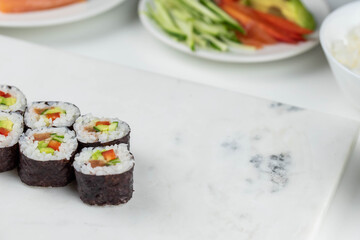 Sushi rolls prepared by professional asian chef with traditional Japanese ingredients. Salmon, rice, vegetables, sesame seeds. 