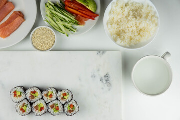 Sushi rolls prepared by professional asian chef with traditional Japanese ingredients. Salmon, rice, vegetables, sesame seeds. 