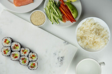 Sushi rolls prepared by professional asian chef with traditional Japanese ingredients. Salmon, rice, vegetables, sesame seeds. Sushi cooking and making concept