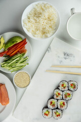 Sushi rolls prepared by professional asian chef with traditional Japanese ingredients. Salmon, rice, vegetables, sesame seeds.  Sushi cooking and making concept